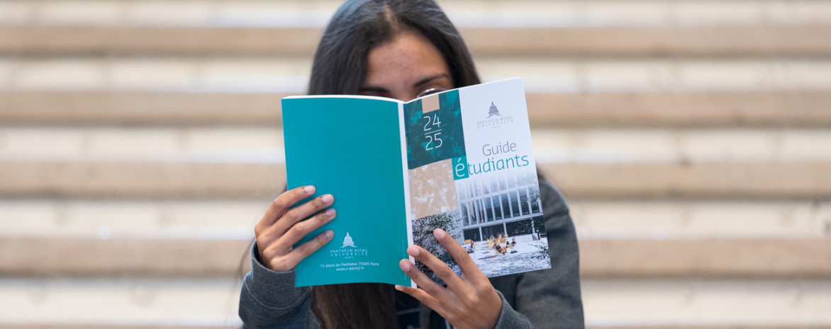 Photo d'un étudiant qui lit le guide étudiant à l'université